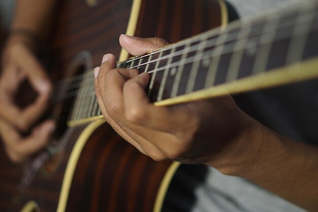 Foto hombre de primer plano tocando la guitarra acústica