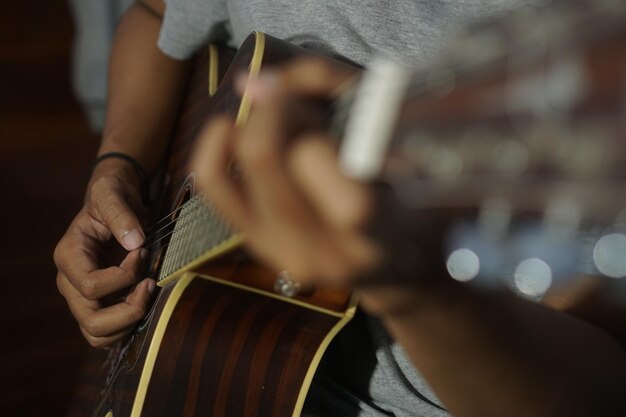 Foto hombre de primer plano tocando la guitarra acústica