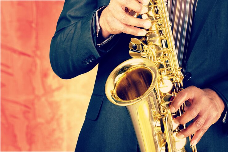 Foto hombre de primer plano tocando el saxofón en el fondo