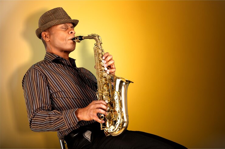 Foto hombre de primer plano tocando el saxofón sobre fondo amarillo