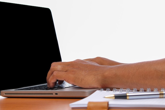 Un hombre en primer plano usando una computadora portátil en el escritorio.