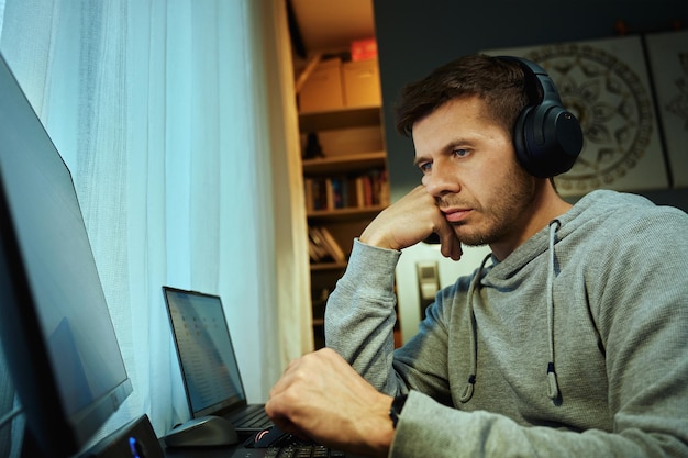 Hombre procrastinando en el lugar de trabajo mientras navega en la computadora
