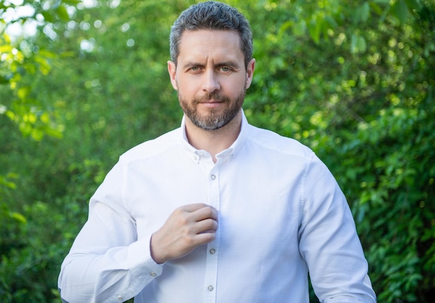 Hombre profesional abotonarse la camisa empresario de fondo natural