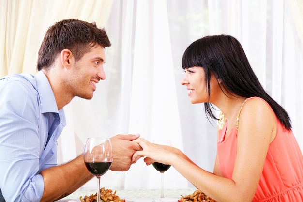 Hombre proponiendo anillo de compromiso a su mujer sobre la mesa del restaurante