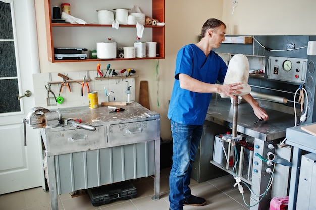 Hombre protésico haciendo prótesis de pierna mientras trabajaba en laboratorio.