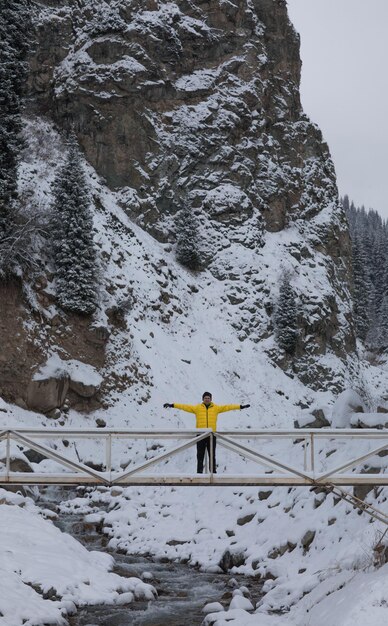 un hombre en un puente de montaña en invierno