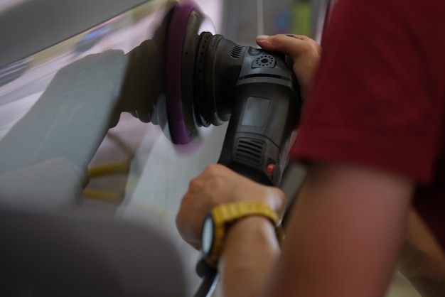 Un hombre pule el cuerpo de un coche manos closeup