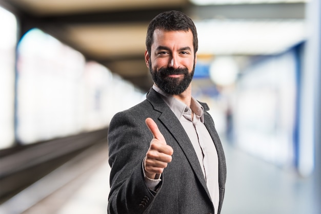 Hombre con el pulgar arriba en fondo unfocused