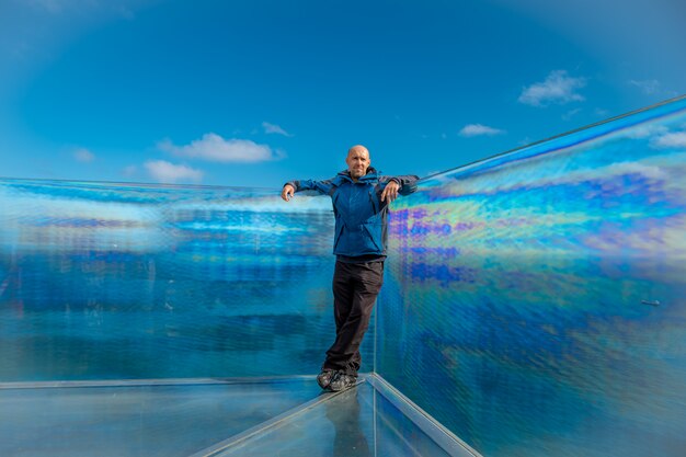 Foto hombre en el punto de vista de cristal en acantilado, skywalk