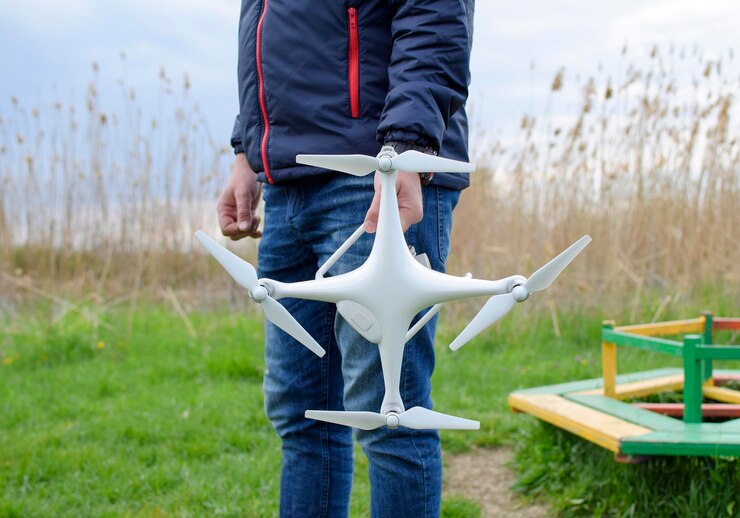 Foto un hombre con un quadrocóptero en sus manos un dron blanco se está preparando para el vuelo phantom