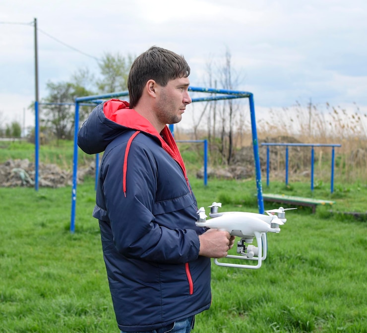 Foto un hombre con un quadrocóptero en sus manos un dron blanco se está preparando para el vuelo phantom