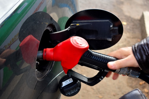 Un hombre que abastece de combustible un automóvil con gasolina.