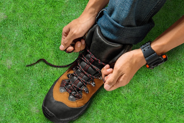 Hombre que ata cordones en sus botas de senderismo