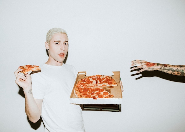 Foto un hombre que come una pizza de pepperoni