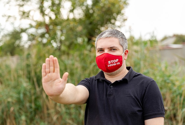 Hombre que cubre su rostro con máscara protectora para protegerse contra virus