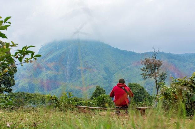 Un hombre que disfruta del paisaje de montaña al borde de un acantilado