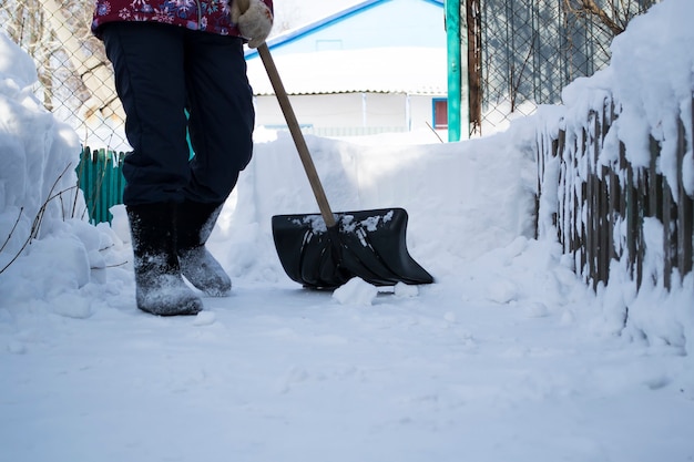 Un hombre que está parado en la nievela niña limpia la nieve con una pata