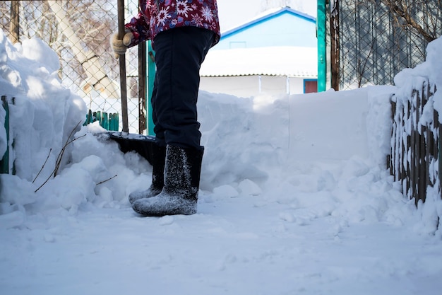 Un hombre que está parado en la nievela niña limpia la nieve con una pata