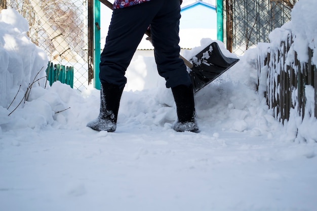 Un hombre que está parado en la nievela niña limpia la nieve con una pata