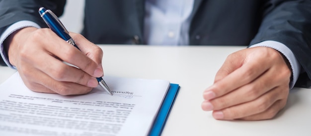 Foto el hombre que firma los documentos del contrato después de leer el hombre que sostiene la pluma y aprueba el informe comercial ley de acuerdo de contrato y conceptos de trato