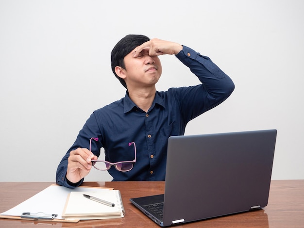 El hombre que intenta quitarse los anteojos siente fatiga visual y dolor de cabeza