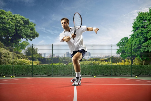 Un hombre que juega al tenis está a punto de golpear una pelota con su raqueta.