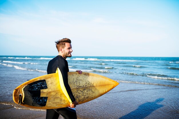 Un hombre que lleva una tabla de surf