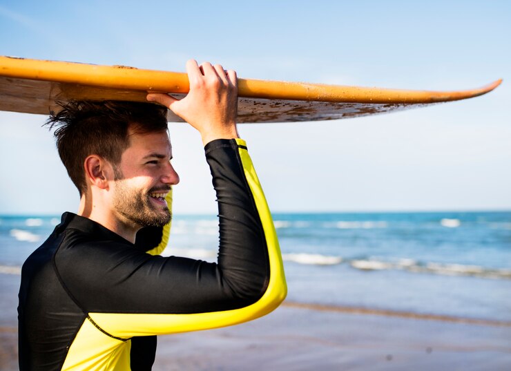 Un hombre que lleva una tabla de surf