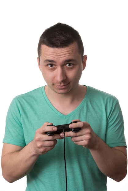 Hombre que llevaba una camiseta verde y está jugando videojuegos sobre fondo blanco aislado