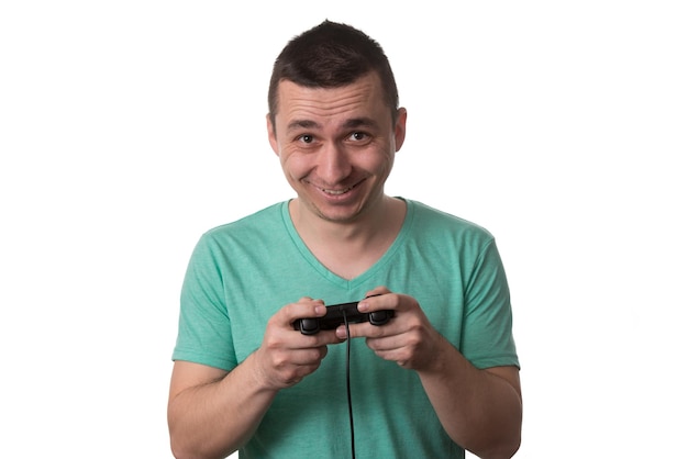 Hombre que llevaba una camiseta verde y está jugando videojuegos sobre fondo blanco aislado