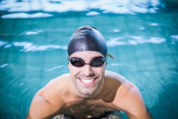 Hombre que llevaba gafas de natación en la piscina