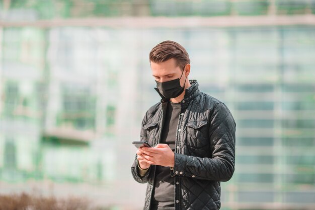 Hombre que llevaba una máscara y con smartphone en la calle