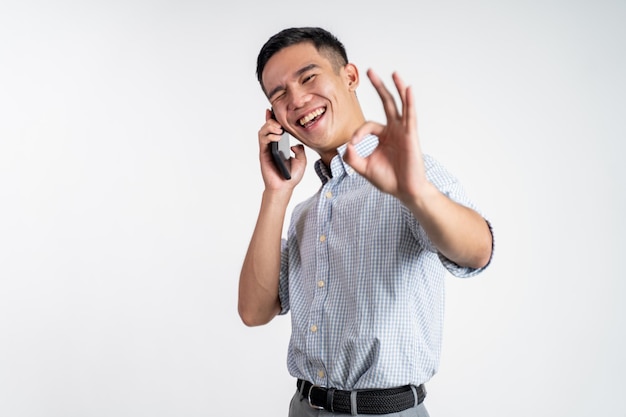 Hombre que muestra un gesto correcto mientras realiza una llamada telefónica