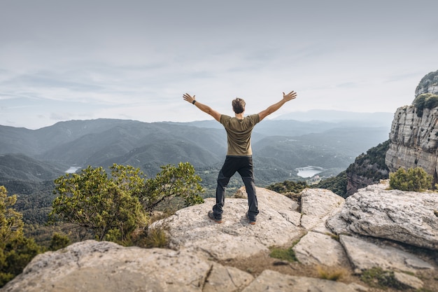 Hombre que muestra la libertad en la montaña.