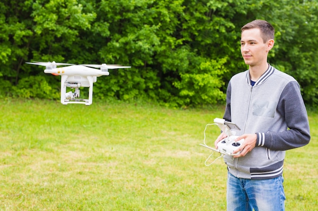 Hombre que opera Drone volando o flotando por control remoto en la naturaleza