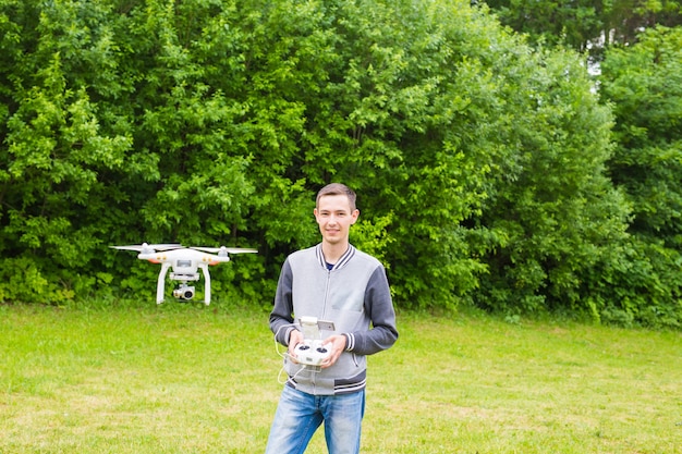 Hombre que opera Drone volando o flotando por control remoto en la naturaleza
