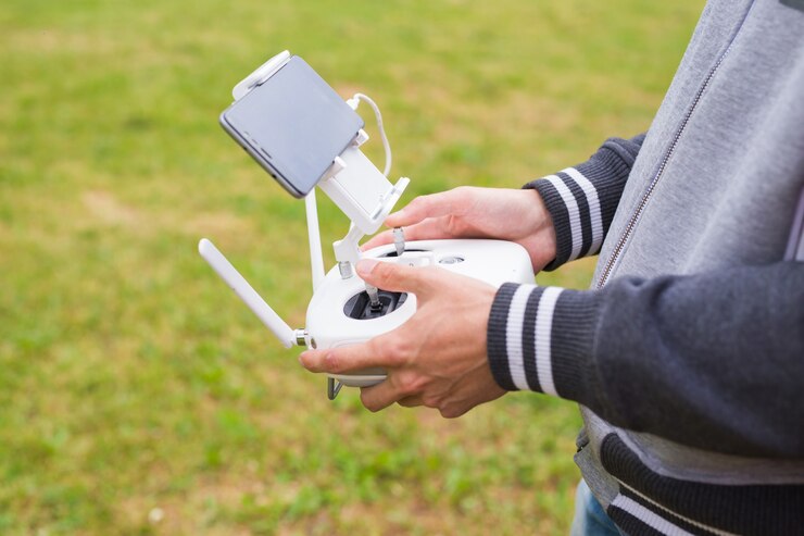 Foto hombre que opera drones volando o flotando por control remoto en la naturaleza