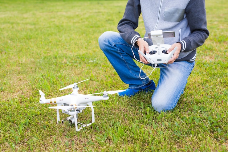 Foto hombre que opera drones volando o flotando por control remoto en la naturaleza