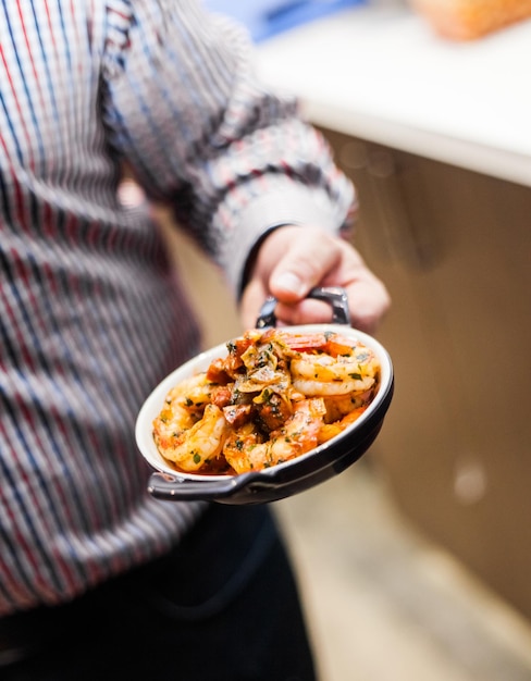 Hombre que presenta una comida típica portuguesa tradicional