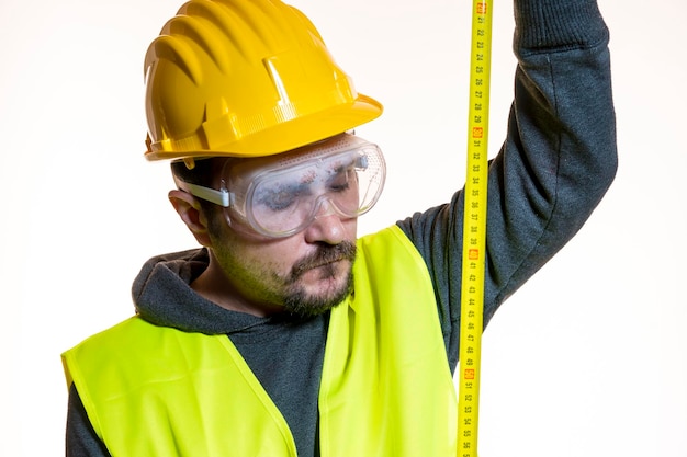 un hombre que quiere hacer un trabajo sin conocimiento, un trabajo sin experiencia. Hágalo usted mismo, hombre vestido con casco de constructor amarillo con gafas protectoras listo para comenzar el trabajo de construcción