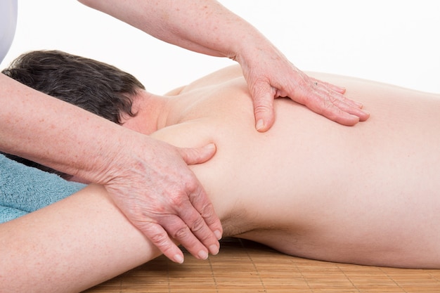 Hombre que recibe el masaje de espalda del masajista mujer en el centro de spa