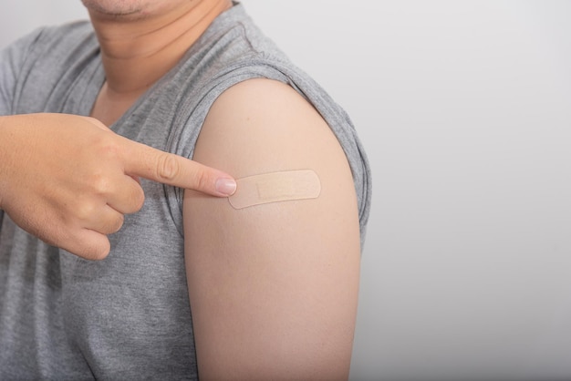 El hombre que señala el brazo ha sido vacunado contra COVID