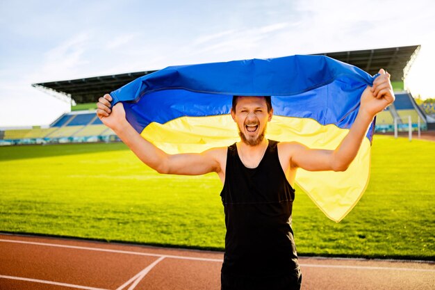 Un hombre que sostiene una bandera azul y amarilla que dice ucrania.