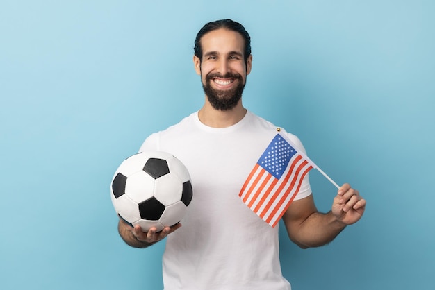 Hombre que sostiene la bandera de los estados unidos de américa y la liga de fútbol unida de pelota blanca y negra de fútbol