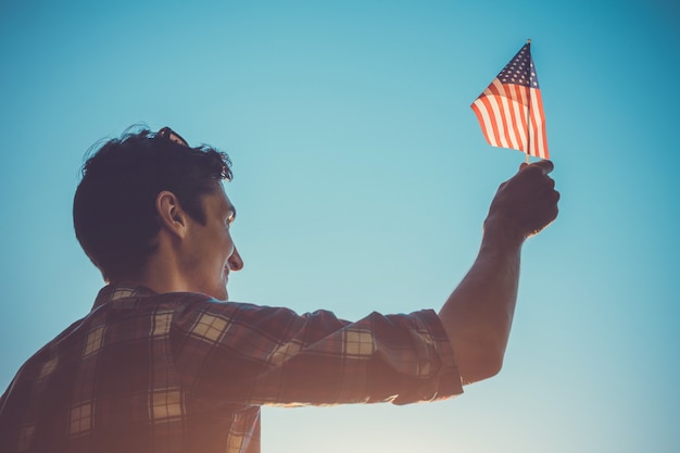 Hombre que sostiene la bandera de Estados Unidos. Celebrando el Día de la Independencia de América