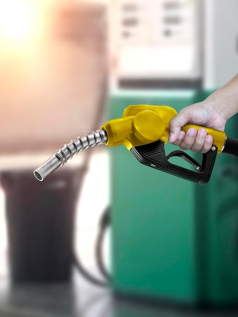 Hombre que sostiene la boquilla de combustible en la gasolinera