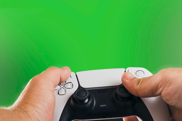 Hombre que sostiene un controlador de juego blanco de próxima generación aislado sobre fondo verde. Chroma Key.