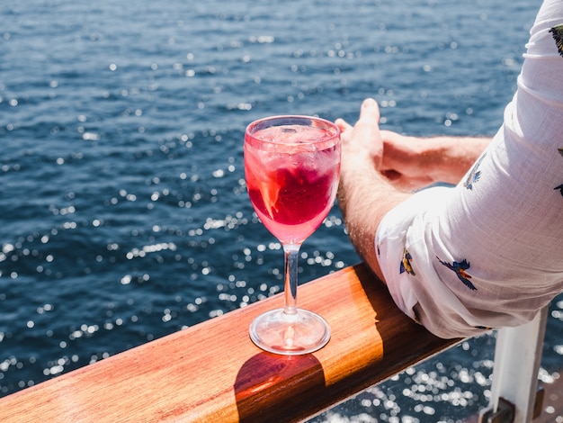 Foto hombre que sostiene un hermoso vaso de vino rosado