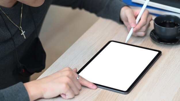 hombre que sostiene el lápiz óptico apuntando en la pantalla de la tableta digital.