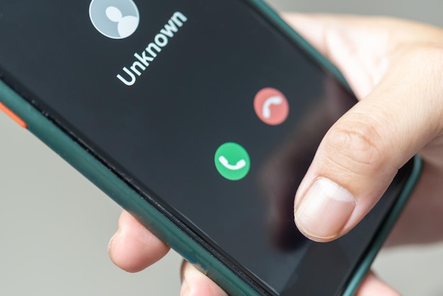 Hombre que sostiene una llamada de teléfono móvil de un número desconocido Fraude de estafa o phishing con concepto de teléfono inteligente Hombre que responde a una llamada entrante